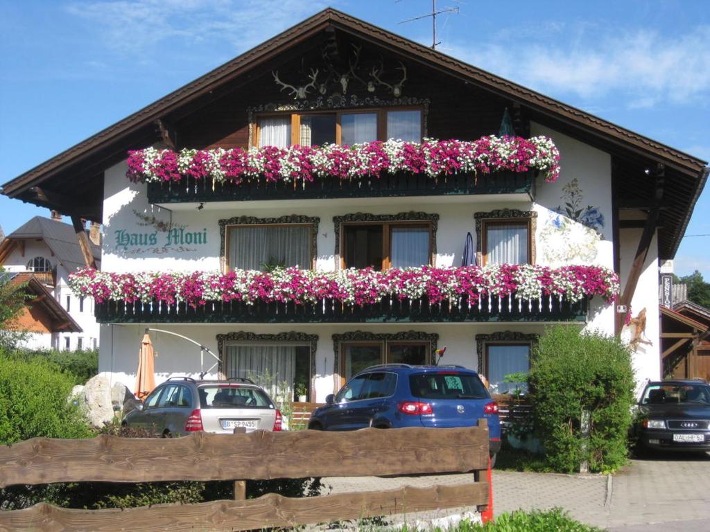 un bâtiment avec des fleurs sur son côté dans l'établissement Haus Moni, à Schwangau