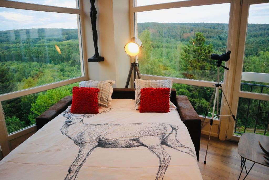 een slaapkamer met een bed en een groot raam bij Ardennes Forest in Nassogne