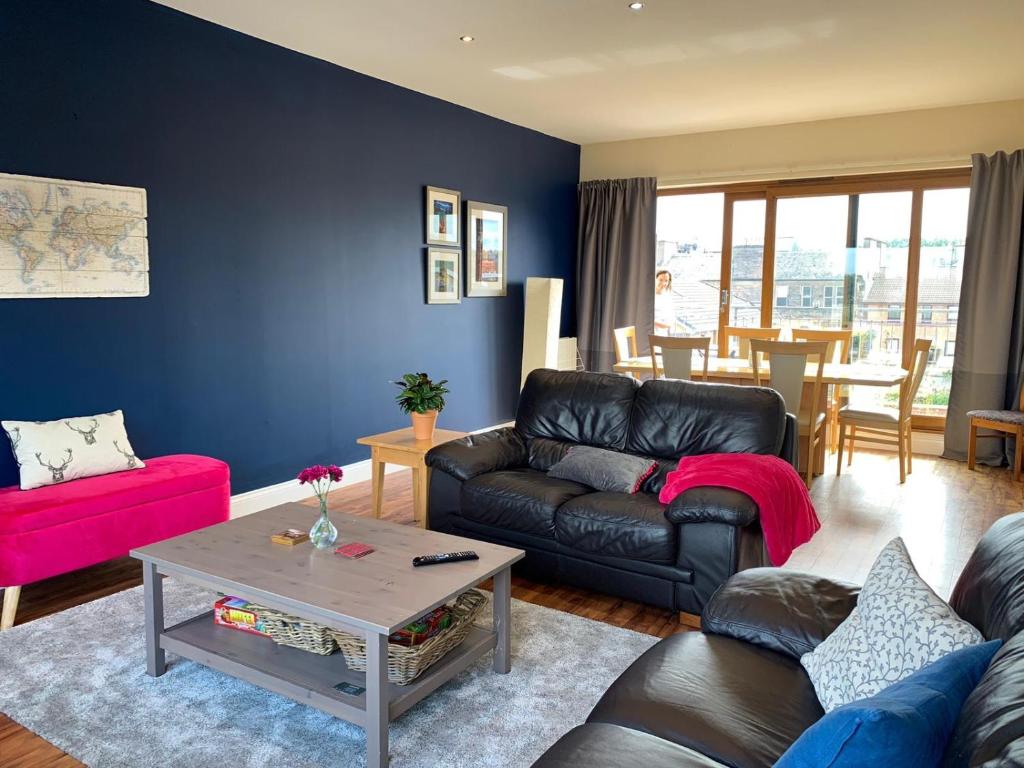 a living room with a couch and a table at 5 Bedroom Central Penthouse Apartment in Edinburgh