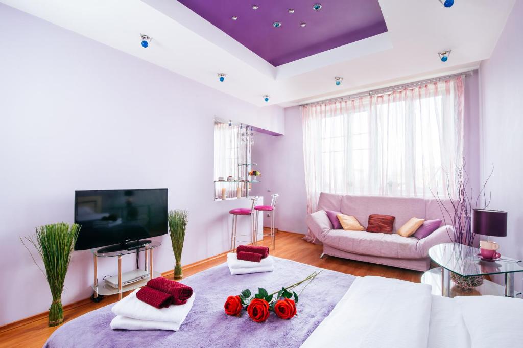 VIP-Kvartira by Nezavisimosti 46 في مينسك: غرفة معيشة مع أريكة بيضاء وسقف أرجواني