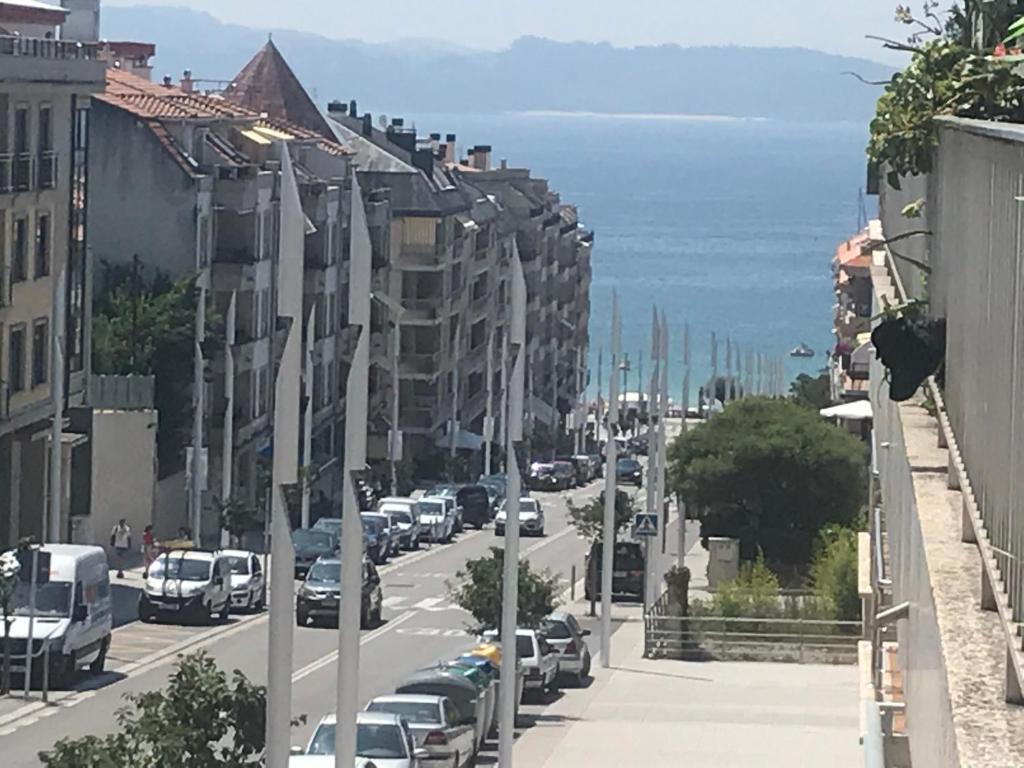 eine Stadtstraße mit am Straßenrand geparkten Autos in der Unterkunft Apartamentos Trebol in Sanxenxo