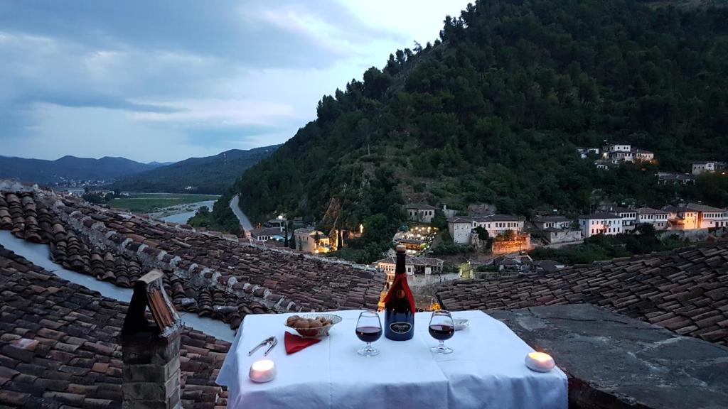 uma mesa com dois copos de vinho no topo de uma montanha em Guest House Panorama em Berati