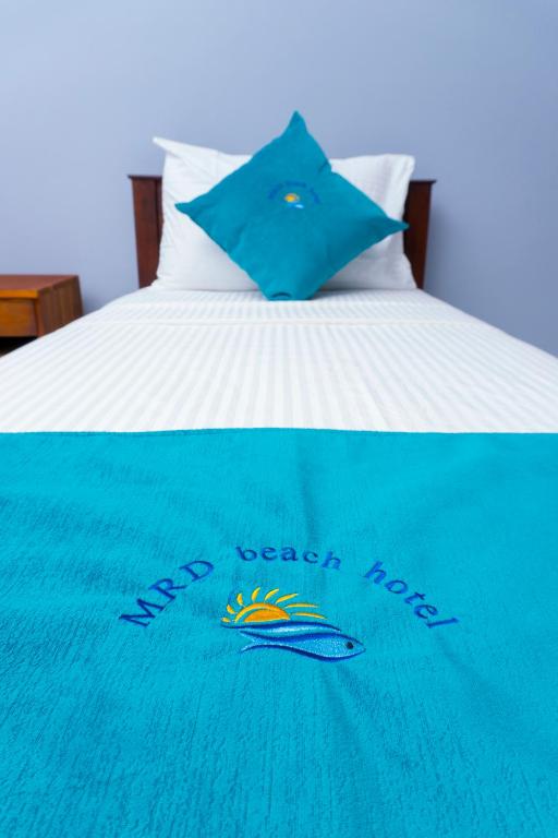a blue blanket on top of a bed at MRD Beach Hotel in Trincomalee