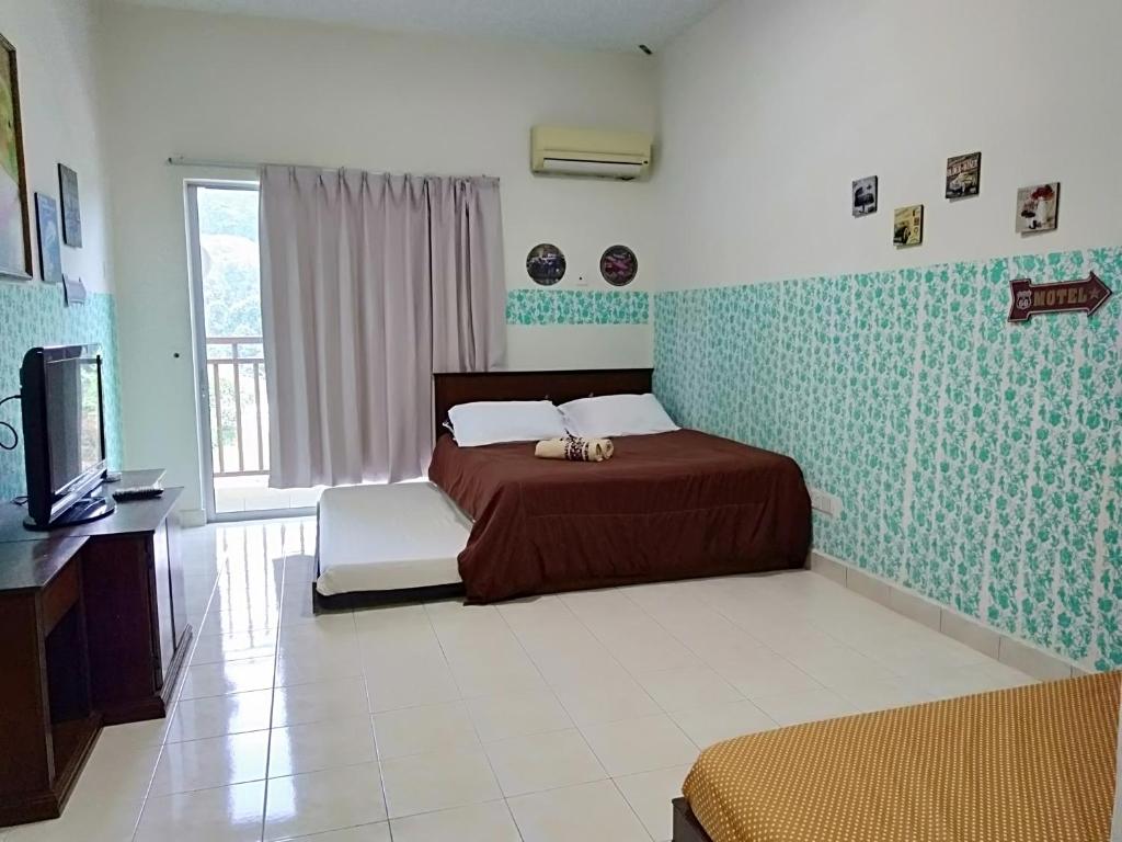 een slaapkamer met een bed en een televisie. bij Homestay Pagar Buruk Bukit Merah L4 - AIR CONDITIONED in Kampong Selemat
