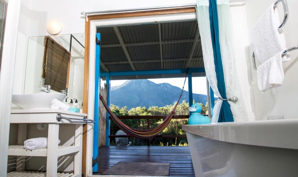 a bathroom with a view of a mountain at Tsitsikhaya Lodge in Stormsrivier