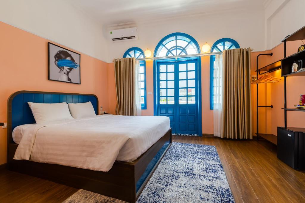 una camera con un letto e una porta blu di The Poppy Villa & Hotel a Hanoi