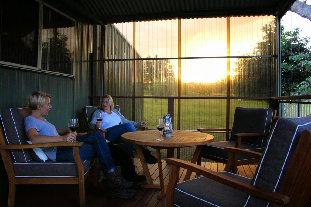 two women sitting at a table with glasses of wine at Walsh Farm Farmstay in Milton