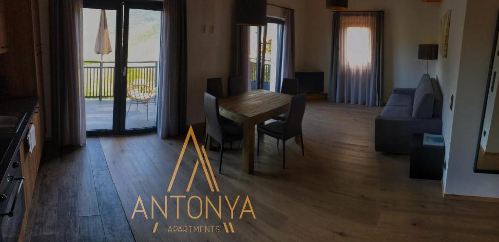 ein Wohnzimmer mit einem Holztisch und Stühlen in der Unterkunft Antonya Apartments in Schenna