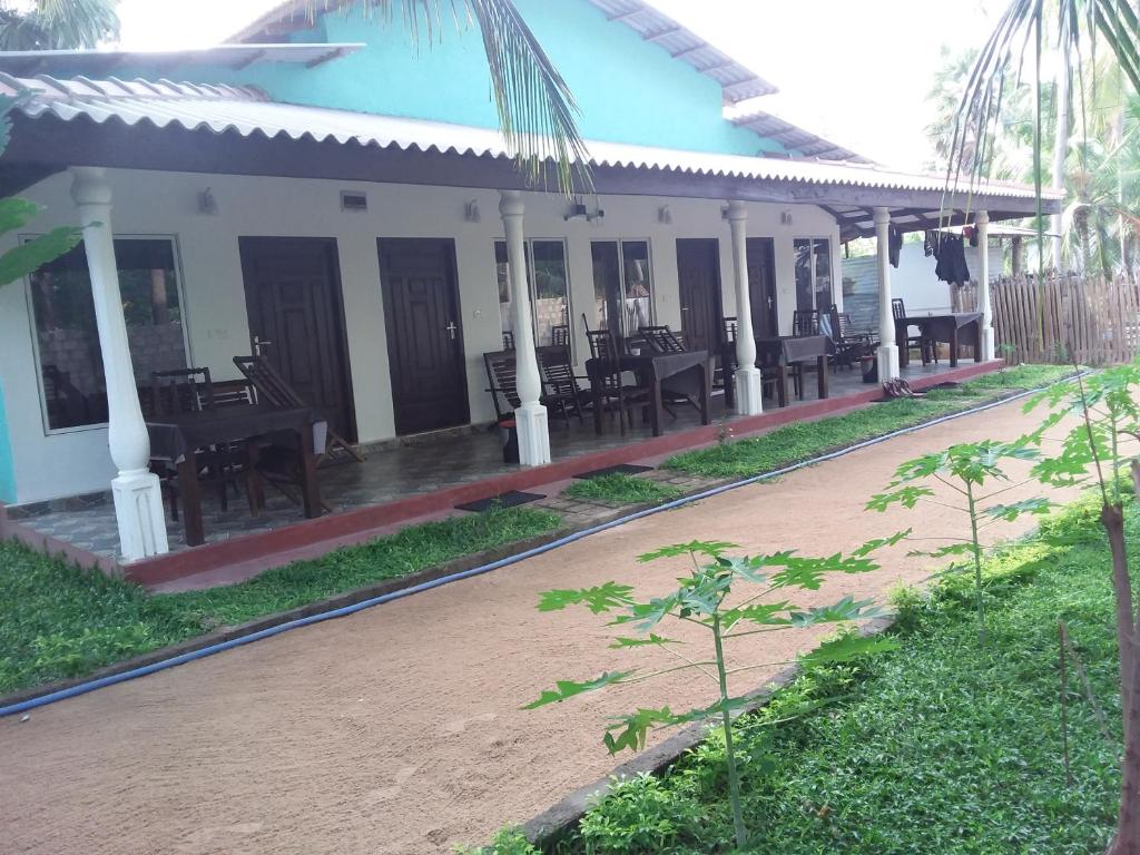 a building with tables and chairs on the side of it at Theepan's Home in Nilaveli