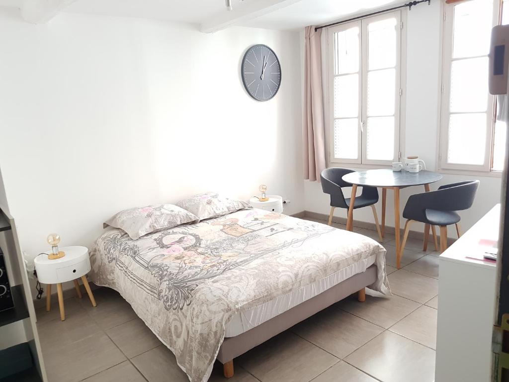 a bedroom with a bed and a table and chairs at Charmant studio au coeur de St Leu hyper centre in Amiens