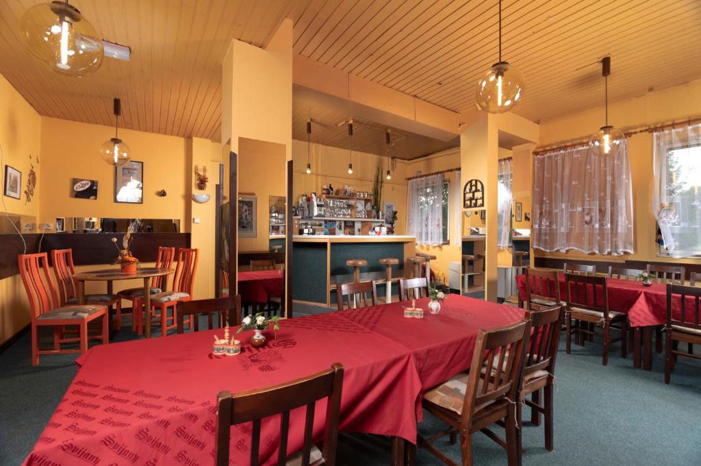 a dining room with a red table and chairs at Ubytovna Z-SPORT in Nové Město nad Metují