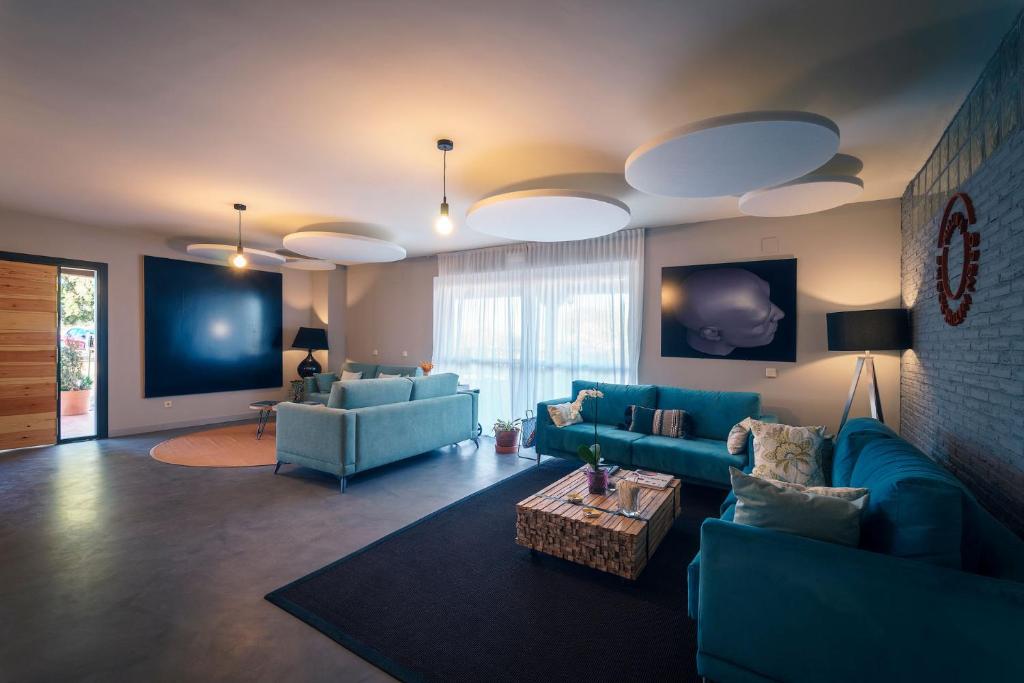 una sala de estar con sofás azules y una mesa. en Miluna, en Hormigos