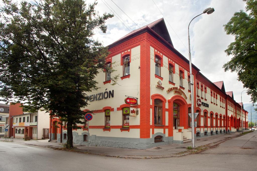 a red and white building on the corner of a street at Penzion Burra in Vrútky