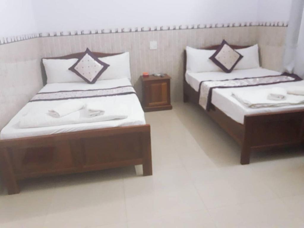 una camera con due letti e un tavolo di Minh Minh Hotel a Quy Nhon
