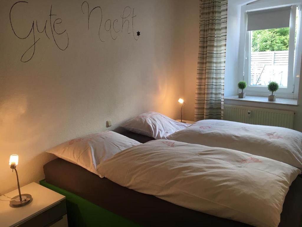 2 Betten in einem Schlafzimmer mit einem Schild an der Wand in der Unterkunft Gemütliches Appartement nähe Zentrum mit Küche in Haßfurt