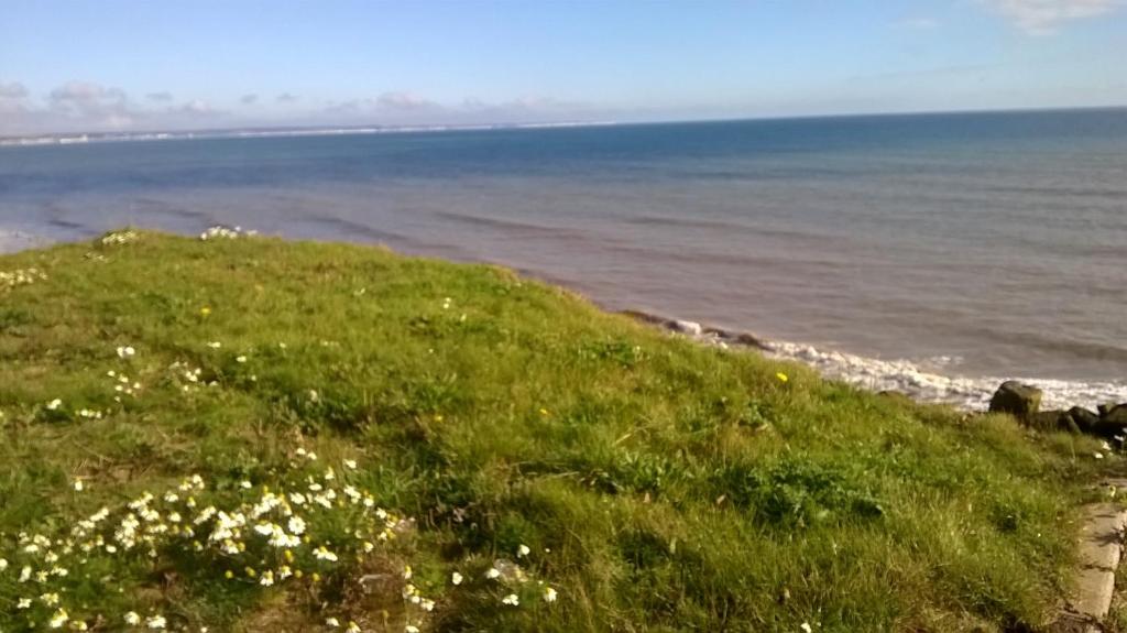 una collina erbosa con l'oceano sullo sfondo di SJ Seaside Chalet a Bridlington