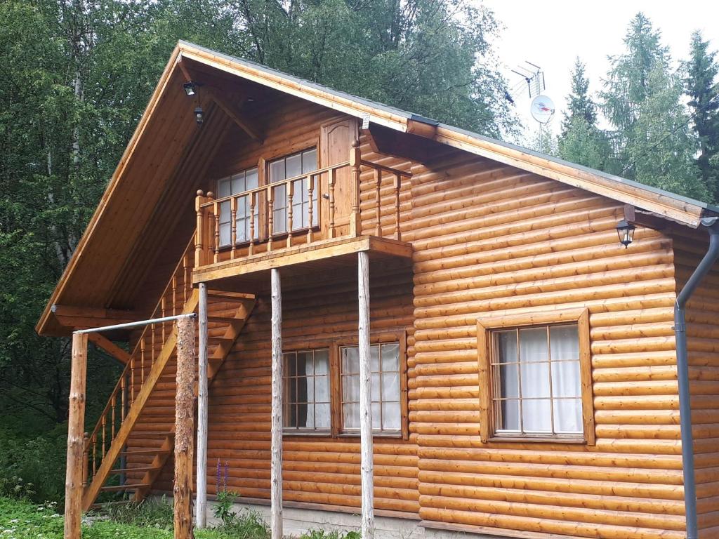a log cabin with a staircase on the side of it at Коттедж в Финляндии (Тохмаярви) in Tohmajärvi