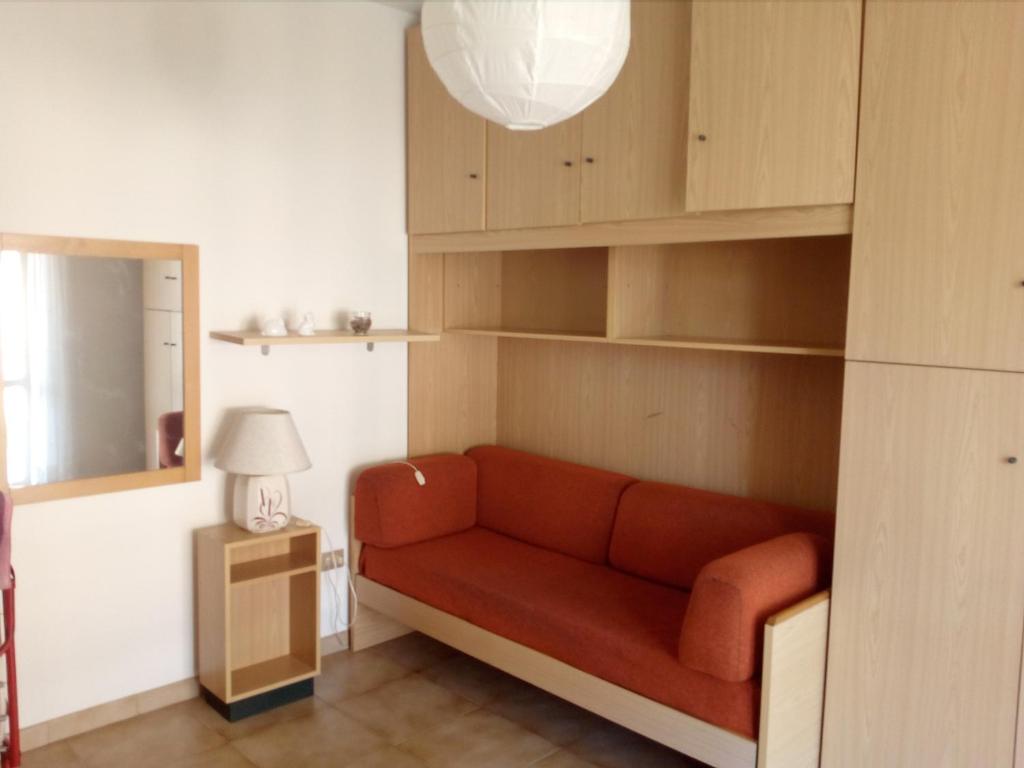 een woonkamer met een rode bank en een lamp bij AllogGio' in Calice Ligure