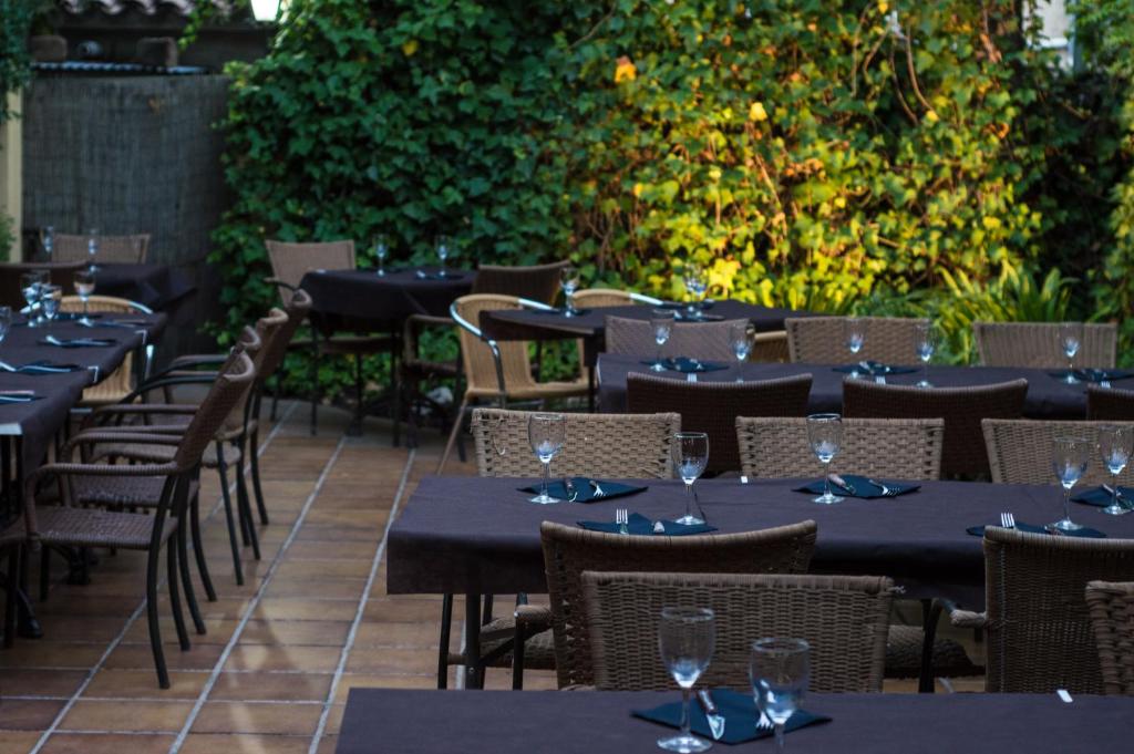 uma fila de mesas e cadeiras num restaurante em L'Argolla Hotel-Pizzeria em Santa Coloma de Farners