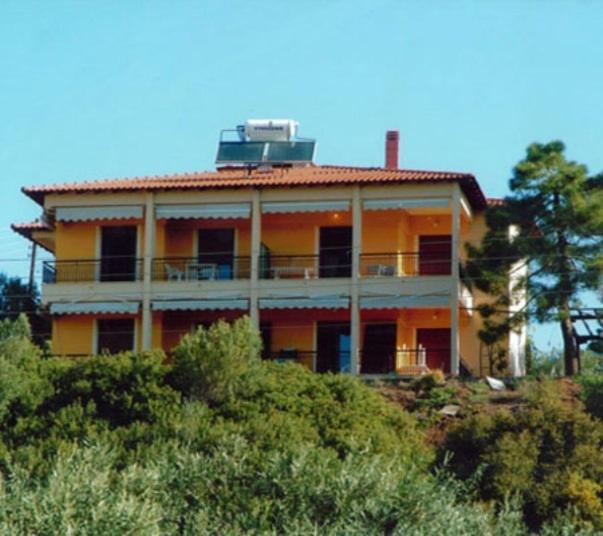 a large yellow house on top of a hill at Kostas House in Gerakini