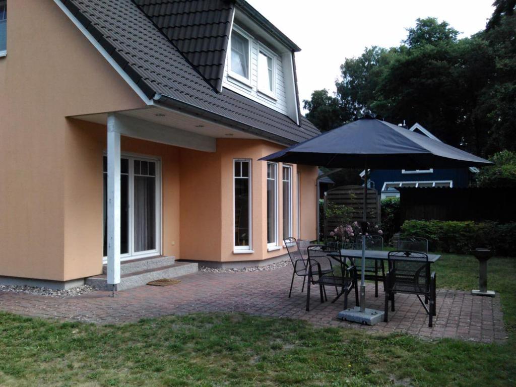 プレローにあるFerienhaus "Kleist "の家の前にテーブルと傘付きのパティオ