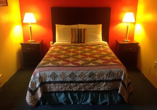 ein Schlafzimmer mit einem großen Bett mit zwei Lampen in der Unterkunft Holly Motel Southampton in Southampton