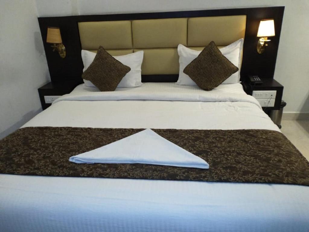 a large bed with a white towel on it at saravanaa residency in Madurai
