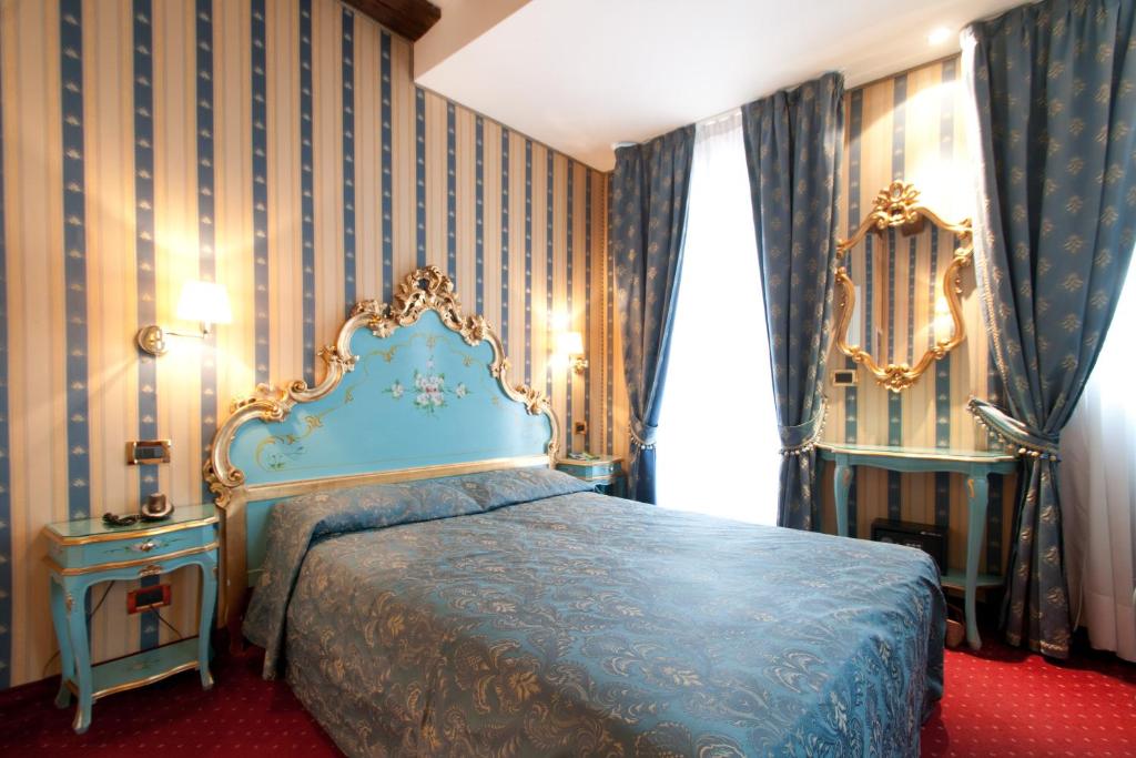 a bedroom with a bed with a blue bedspread at Hotel al Graspo de Ua in Venice