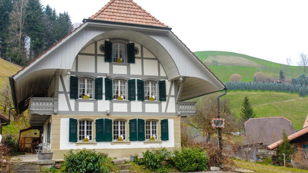 uma pequena casa com persianas verdes em B&B tannen124 em Oberburg