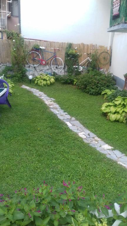 een tuin met een gazon met een fiets erin bij Juliana in Belgrado