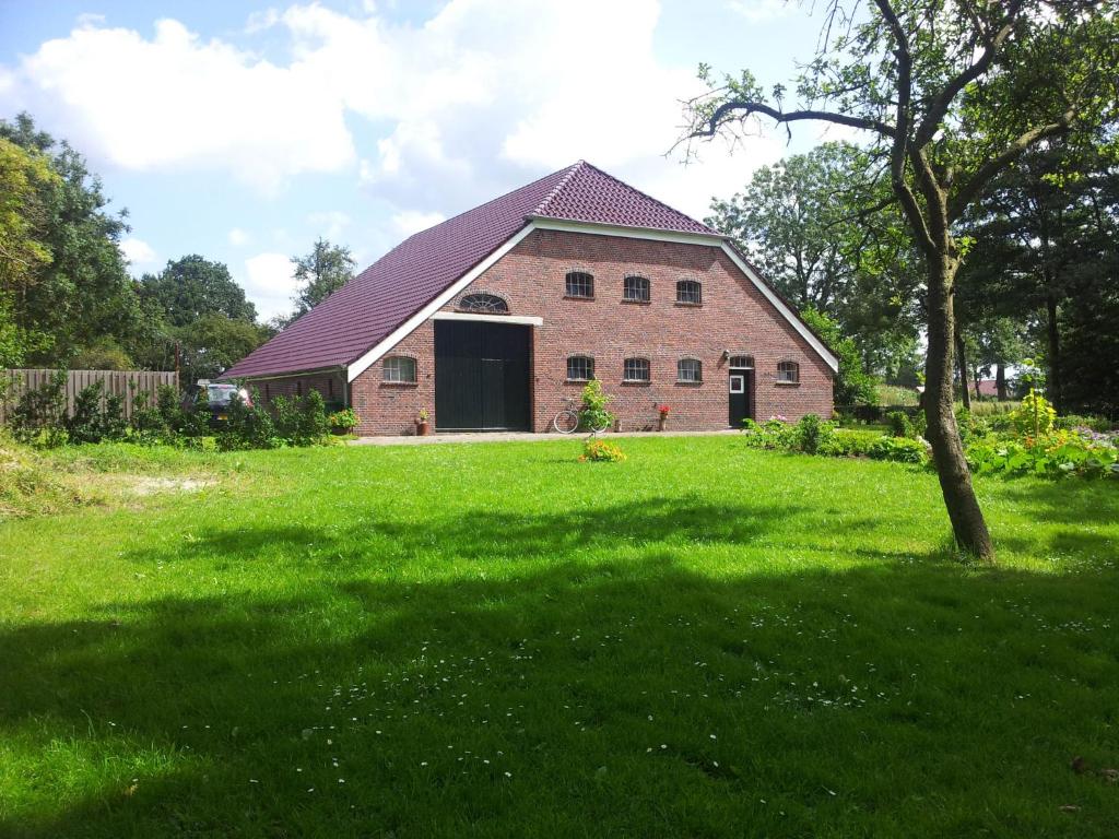 een groot bakstenen gebouw met een grote groene tuin bij De Moane in Akelsbarg