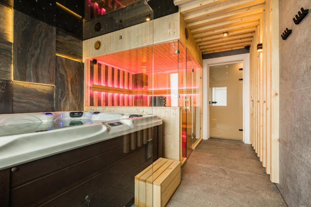 a bathroom with a large tub and a wooden wall at Rezydencja Diamond - 3 minuty jazdy od Termy Bania in Białka Tatrzańska