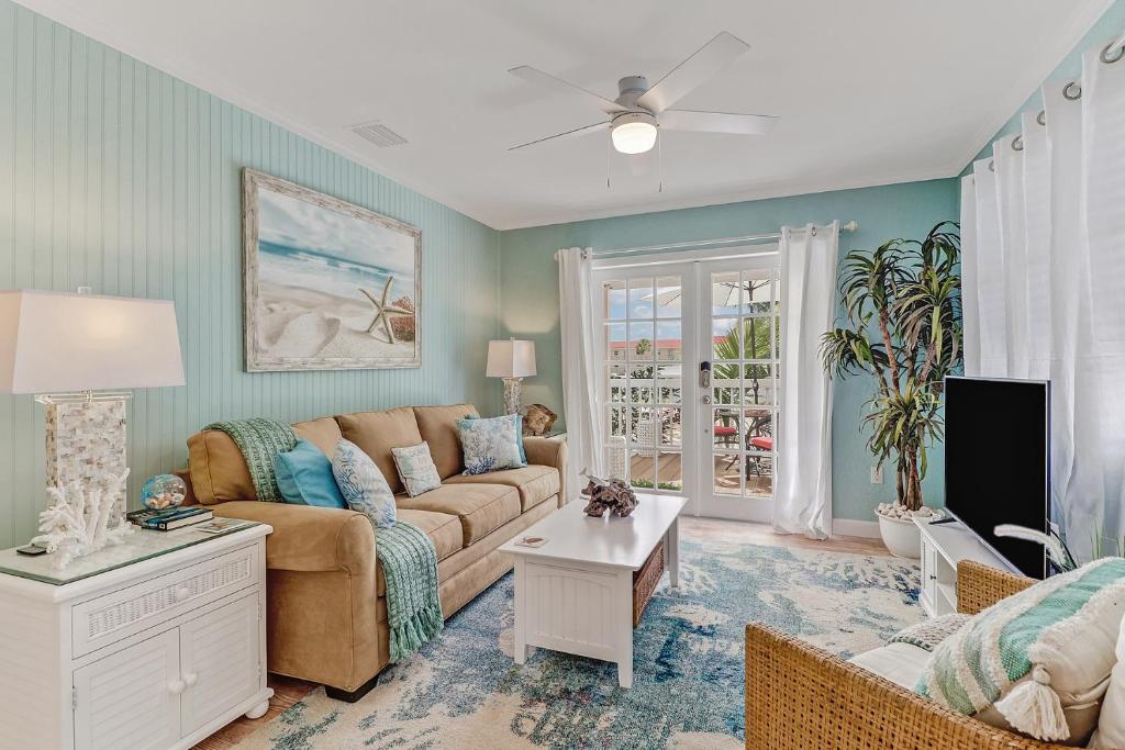 a living room with a couch and a tv at Coral Cottage Retreat in Naples