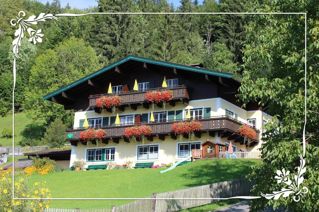 uma casa grande com caixas de flores em Haus Bartlmä em Lofer