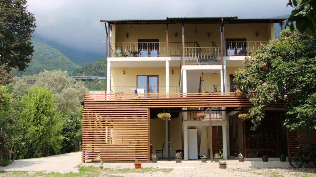 uma casa grande com uma varanda em cima em Guest house LETTO em Gagra