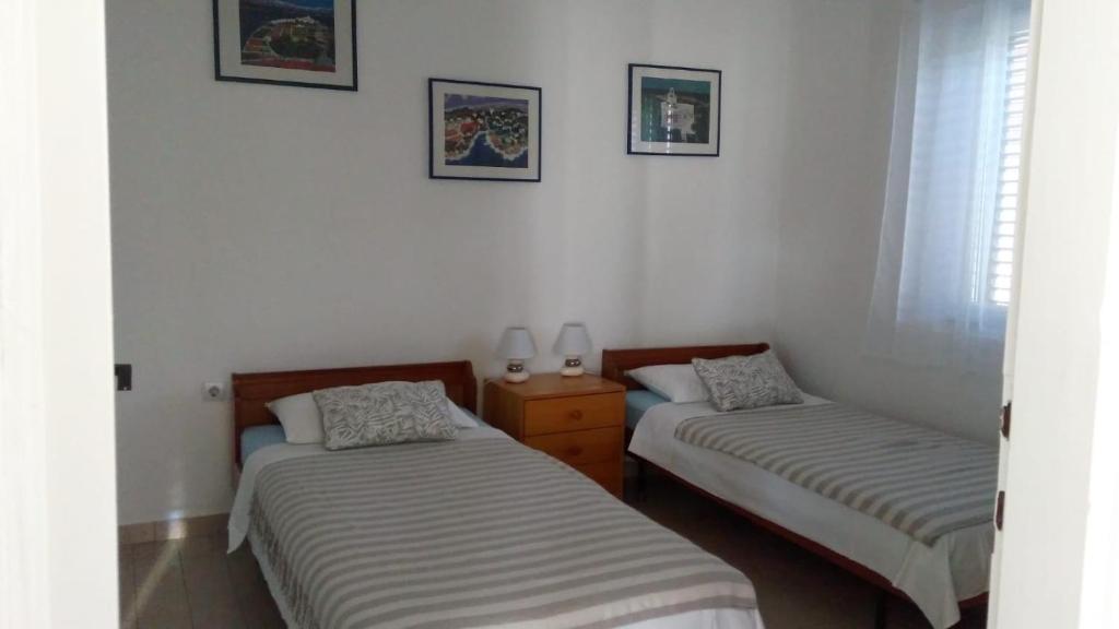 two beds in a room with white walls at Milu in Pirovac