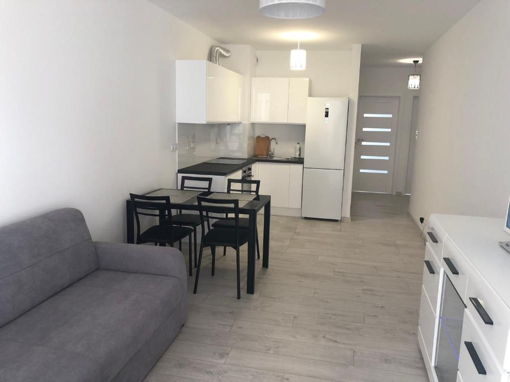 een keuken en woonkamer met een bank en een tafel bij Apartament Winorośli in Warschau