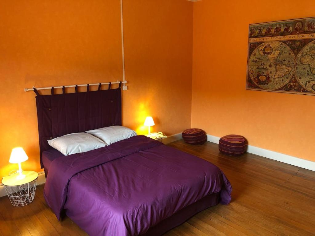 1 dormitorio con 1 cama con sábanas moradas y 2 lámparas en LE REVE DE CHARLES, en Faucompierre