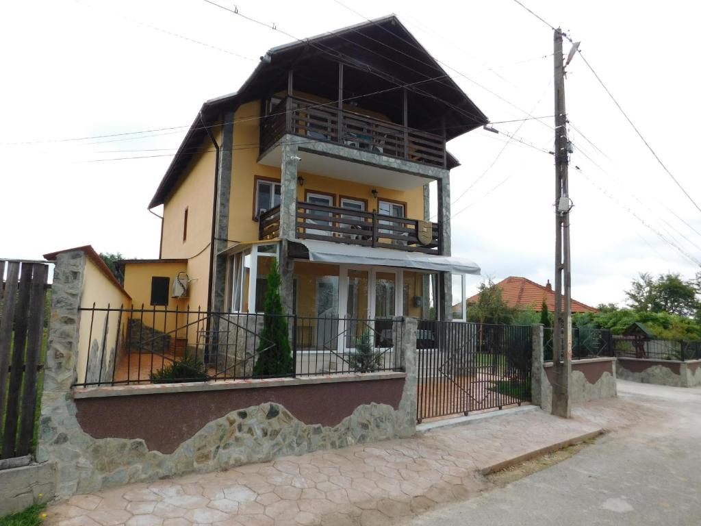 a yellow house with a black roof at Pensiunea Casa Domnitei in Baia de Fier