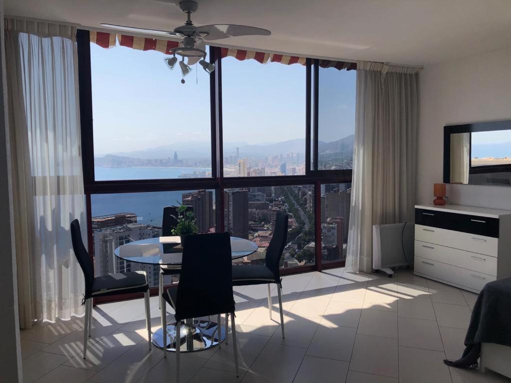 kuchnia ze stołem i krzesłami w pokoju z dużymi oknami w obiekcie View apartments in Gemelos XV w mieście Benidorm