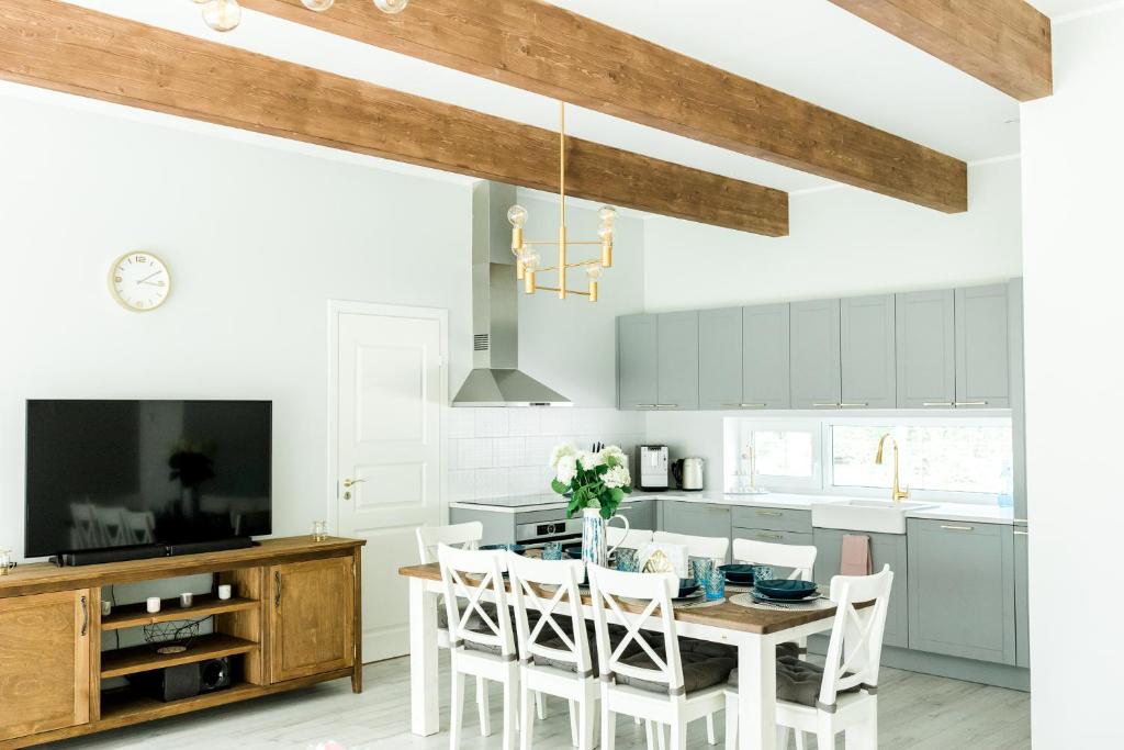 a kitchen with white cabinets and a wooden table and chairs at The Peaceful Vacation- Villa M in Muratsi