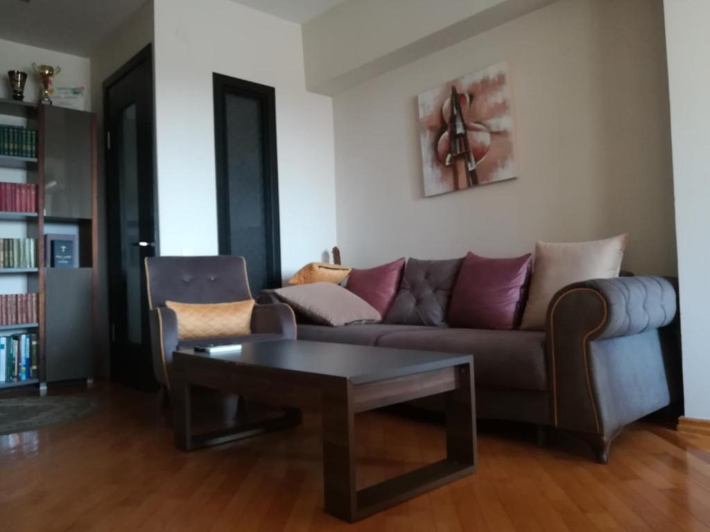 uma sala de estar com um sofá e uma mesa de centro em Davka Apartments em Batumi