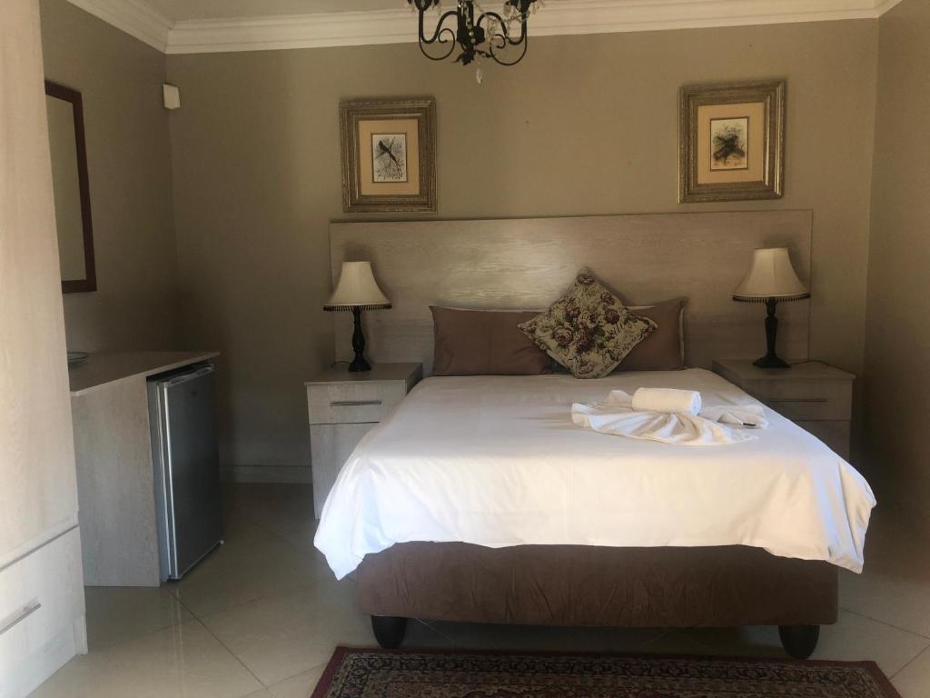 a bedroom with a bed with a towel on it at Sunrise Boutique Hotel in Witbank