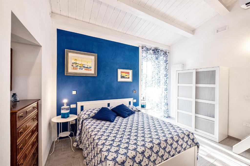 ロジニャーノ・マリッティモにあるLa Villa 31 - Locazione Turisticaの青いベッドルーム(ベッド1台、窓付)
