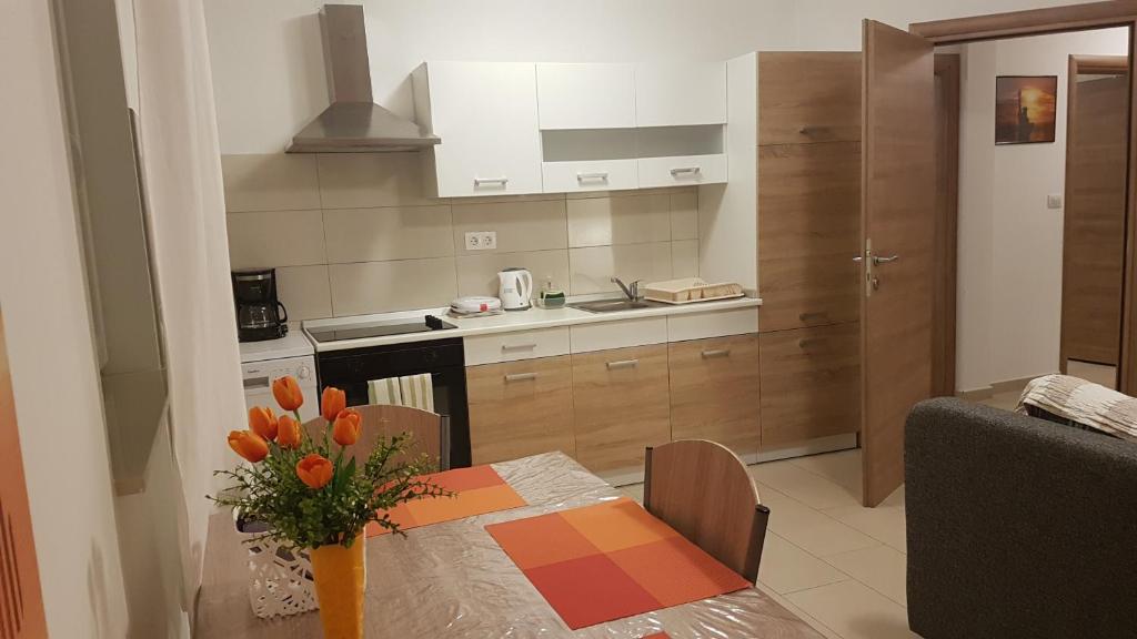 uma cozinha com uma mesa com um vaso de flores em Apartment ORANGE BRIST em Pula