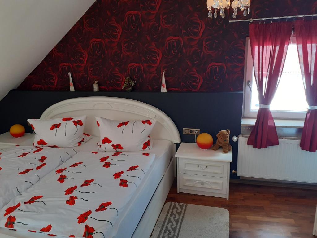 a bedroom with a white bed with red curtains at Gemütliche Zimmer in Kaisersesch