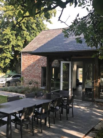 een tafel en stoelen voor een gebouw bij Bij de lindeboom in Maaseik