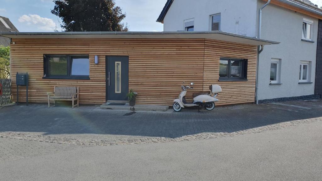 un scooter estacionado frente a una casa en Ferienwohnung Fred en Darscheid