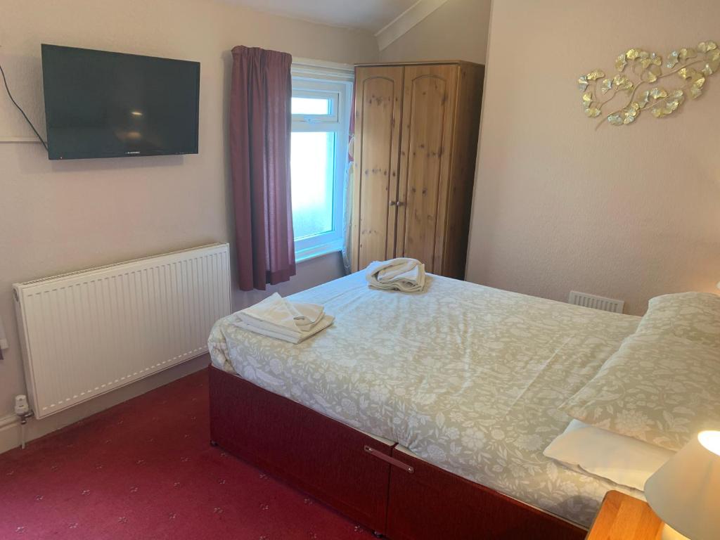 a bedroom with a bed and a television and a window at Wavecrest Lodge in Fleetwood