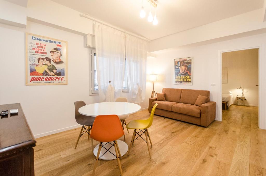 uma sala de estar com uma mesa e cadeiras e um sofá em Il Campo Apartments em Bolonha